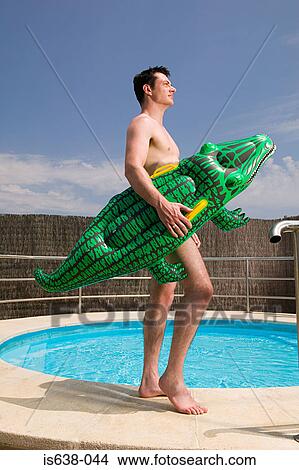 Man carrying an inflatable crocodile View Large Photo Image Picture - Man carrying an inflatable crocodile. Fotosearch