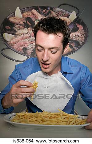 Man eating french fries View Large Photo Image Picture - Man eating french fries . Fotosearch