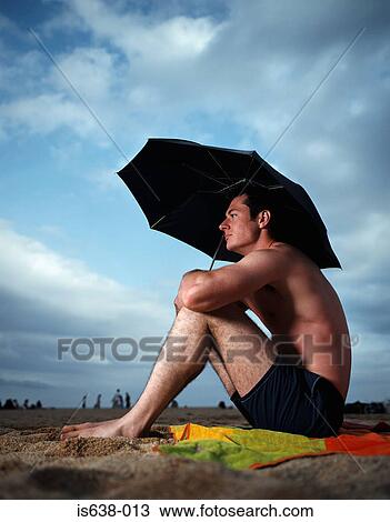 Man with umbrella on beach View Large Photo Image Stock Image - Man with umbrella on beach. Fotosearch