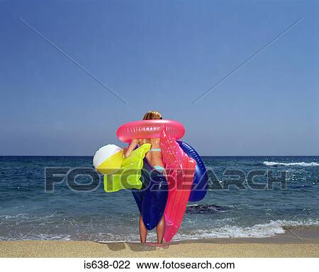 Woman carrying inflatable toys on beach View Large Photo Image Stock Image - Woman carrying inflatable toys on beach. Fotosearch