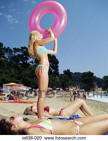 Stock Image - Woman with inflatable ring on beach. Fotosearch