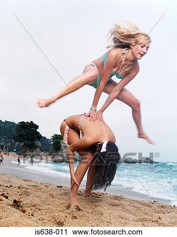 Women leapfrogging on beach View Large Photo Image Stock Image - Women leapfrogging on beach. Fotosearch