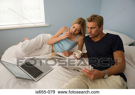 Couple relaxing on their bed View Large Photo Image Stock Photo - Couple relaxing on their bed. Fotosearch
