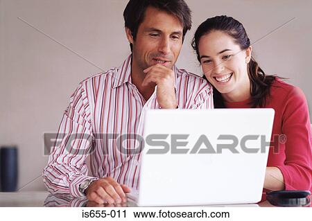 Couple using laptop computer View Large Photo Image Stock Image - Couple using laptop computer. Fotosearch