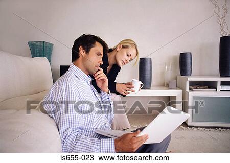 Stock Image - Couple with laptop in the living room. Fotosearch