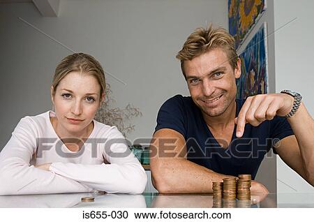 Stock Image - Couple with pile of coins. Fotosearch