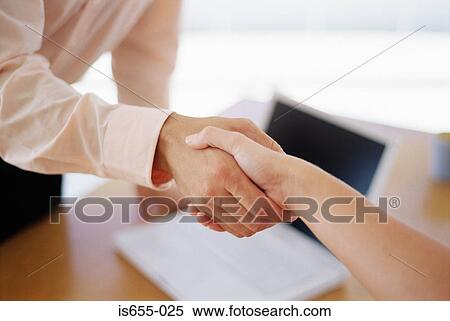 Handshake across a desk View Large Photo Image Stock Photography - Handshake across a desk. Fotosearch