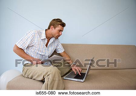 Stock Image - Man settling bill online. Fotosearch