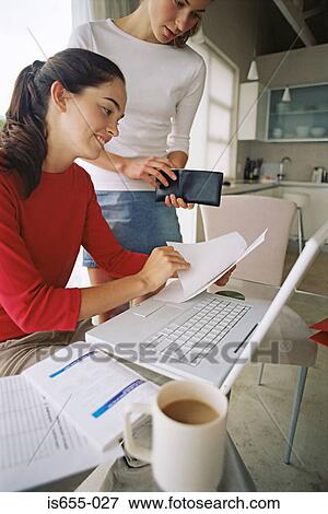 Two women doing their finances View Large Photo Image Stock Photo - Two women doing their finances. Fotosearch
