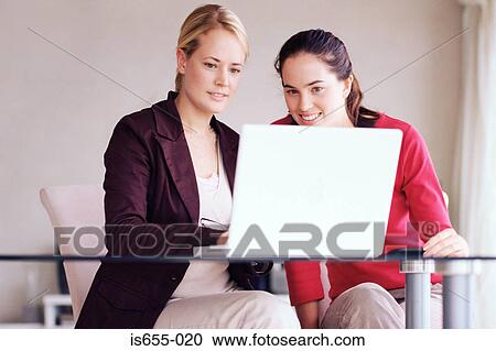 Two women using laptop computer View Large Photo Image Stock Image - Two women using laptop computer. Fotosearch