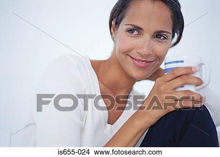 Woman relaxing with a cup of coffee View Large Photo Image Picture - Woman relaxing with a cup of coffee. Fotosearch