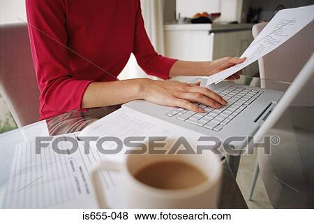Stock Photo - Woman working at kitchen table. Fotosearch