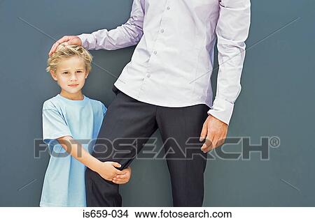 Boy holding his father's leg View Large Photo Image Picture - Boy holding his father's leg. Fotosearch