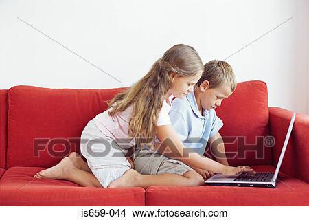 Picture - Brother and sister using laptop. Fotosearch