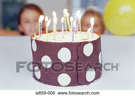 Stock Photography - Children looking at birthday cake. Fotosearch