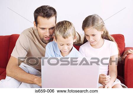 Stock Photograph - Father and children using laptop. Fotosearch