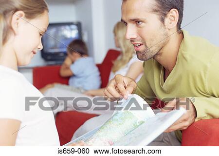 Stock Image - Father and daughter looking at atlas. Fotosearch