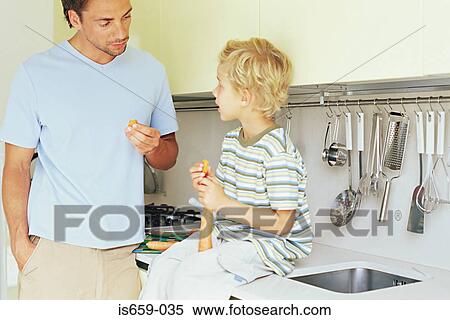 Stock Photography - Father and son eating carrots. Fotosearch