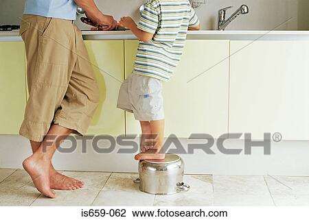 Stock Image - Father and son preparing food. Fotosearch