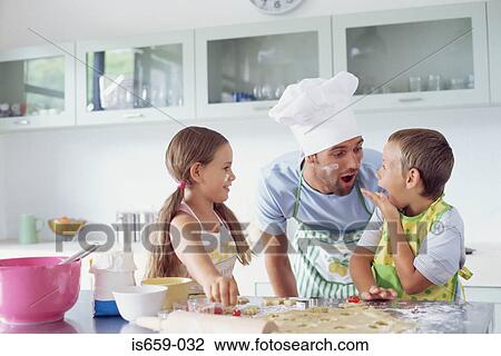Stock Image - Father cooking with children. Fotosearch
