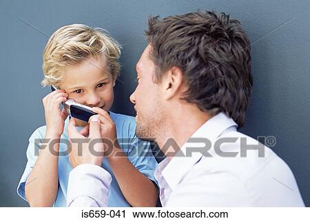 Father letting son use mobile phone View Large Photo Image Stock Image - Father letting son use mobile phone. Fotosearch
