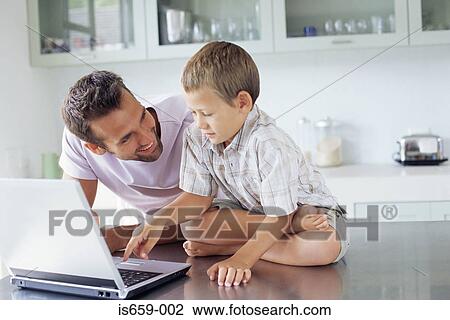 Father showing son how to use laptop View Large Photo Image Stock Image - Father showing son how to use laptop. Fotosearch