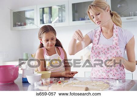 Girl helping mother make biscuits View Large Photo Image Stock Photo - Girl helping mother make biscuits. Fotosearch