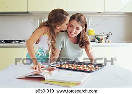Stock Image - Girl kissing mother on the cheek. Fotosearch