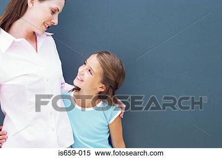Girl looking up at mother View Large Photo Image Stock Photography - Girl looking up at mother. Fotosearch