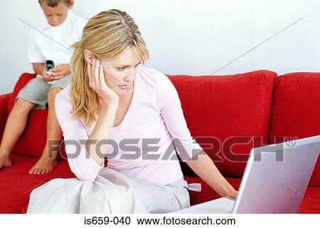 Mother and son using laptop and mobile phone View Large Photo Image Stock Image - Mother and son using laptop and mobile phone. Fotosearch