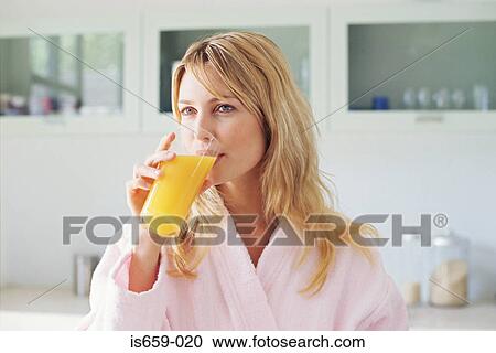 Stock Image - Woman drinking orange juice. Fotosearch