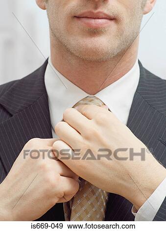 Stock Photo - Businessman adjusting his tie. Fotosearch