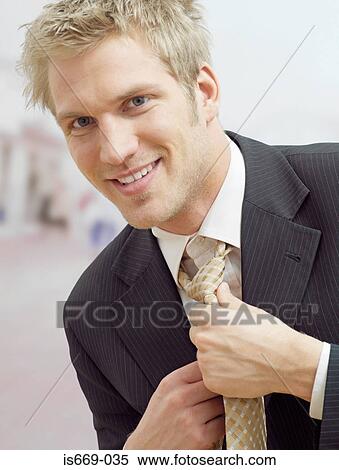 Businessman adjusting his tie View Large Photo Image Stock Photography - Businessman adjusting his tie. Fotosearch