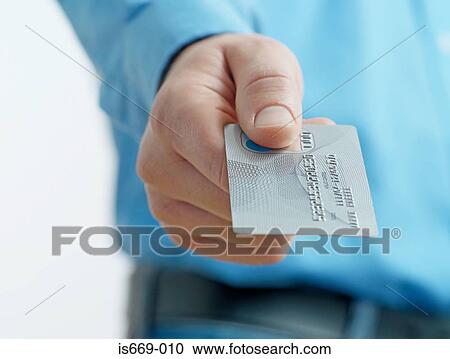 Stock Image - Man holding out credit card. Fotosearch