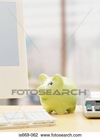 Stock Image - Piggy bank on a desk. Fotosearch