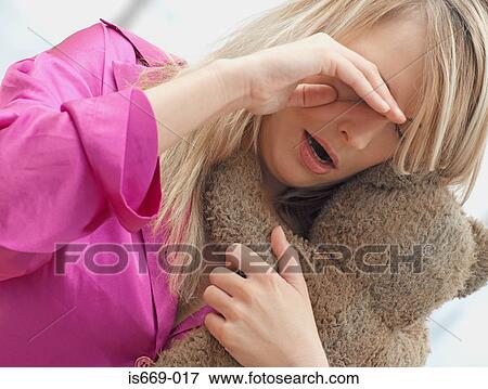 Stock Photo - Woman in pyjamas holding teddy bear. Fotosearch