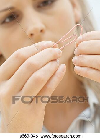 Woman looking at paperclip View Large Photo Image Stock Photography - Woman looking at paperclip. Fotosearch