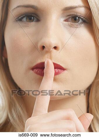 Stock Photo - Woman putting a finger to her lips. Fotosearch