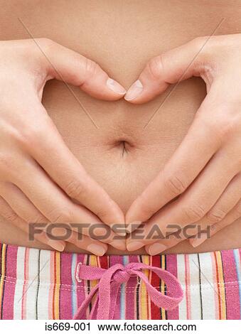 Woman's hands around her navel in a heart shape View Large Photo Image Stock Image - Woman's hands around her navel in a heart shape. Fotosearch