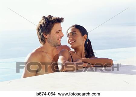Couple at the edge of swimming pool View Large Photo Image Picture - Couple at the edge of swimming pool. Fotosearch