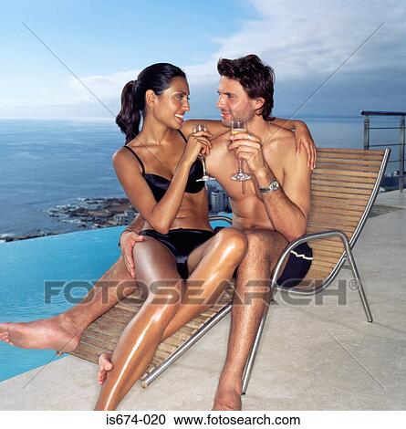 Couple on a sunlounger with champagne View Large Photo Image Stock Image - Couple on a sunlounger with champagne. Fotosearch