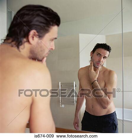 Man looking at his reflection View Large Photo Image Stock Photo - Man looking at his reflection. Fotosearch
