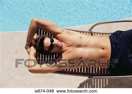 Man sunbathing by the pool View Large Photo Image Stock Photo - Man sunbathing by the pool. Fotosearch