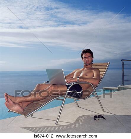 Man using laptop by the pool View Large Photo Image Stock Image - Man using laptop by the pool. Fotosearch
