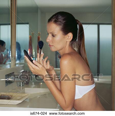 Woman putting on make-up View Large Photo Image Picture - Woman putting on make-up. Fotosearch