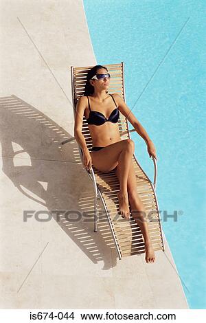 Picture - Woman sunbathing by the pool. Fotosearch