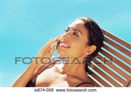 Woman using mobile by the pool View Large Photo Image Stock Photo - Woman using mobile by the pool. Fotosearch