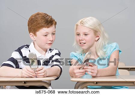 Stock Photo - Boy and girl with mobile phones. Fotosearch