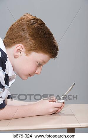 Picture - Boy sending a text message. Fotosearch