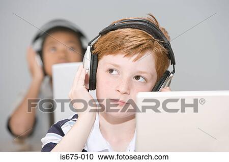 Boys listening to headphones View Large Photo Image Stock Image - Boys listening to headphones. Fotosearch